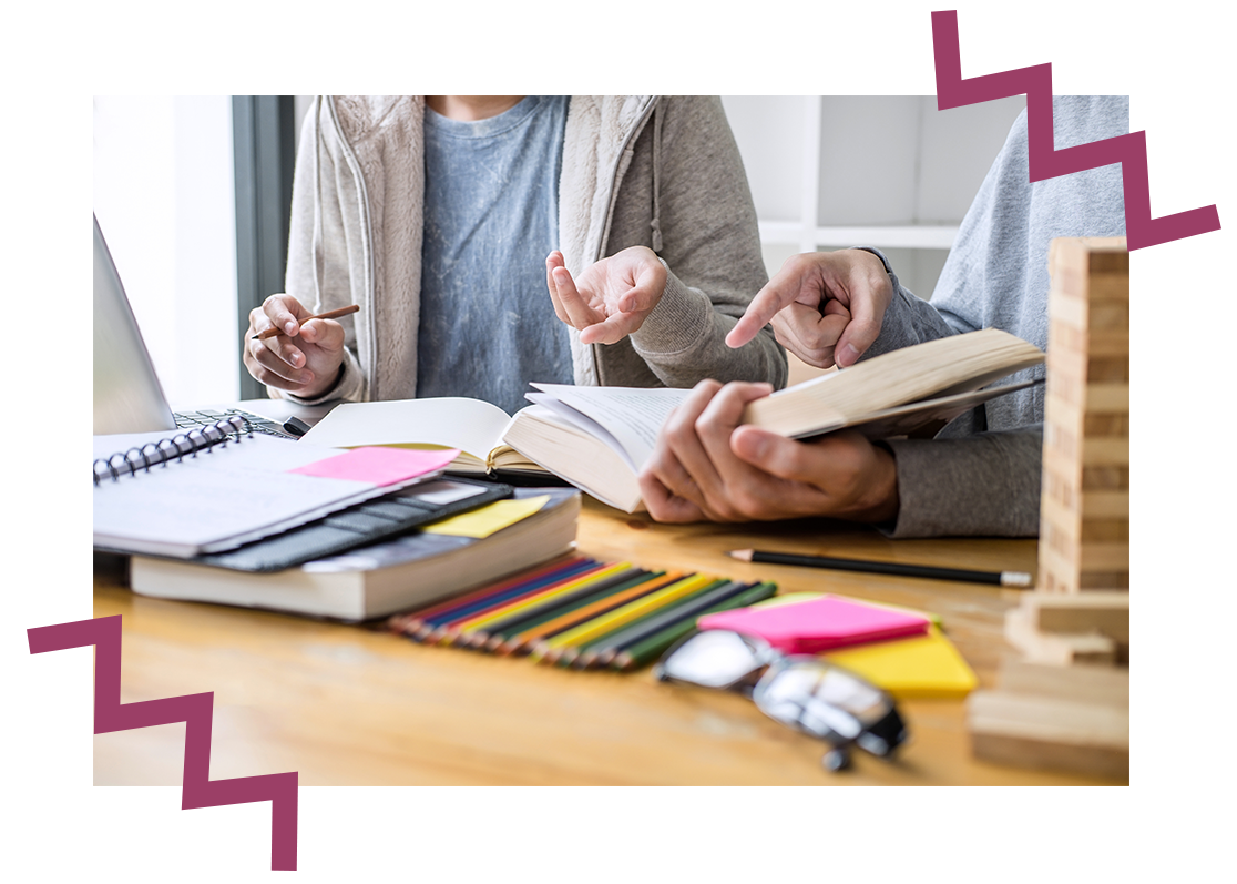 Personen arbeiten gemeinsam mit Lernunterlagen.