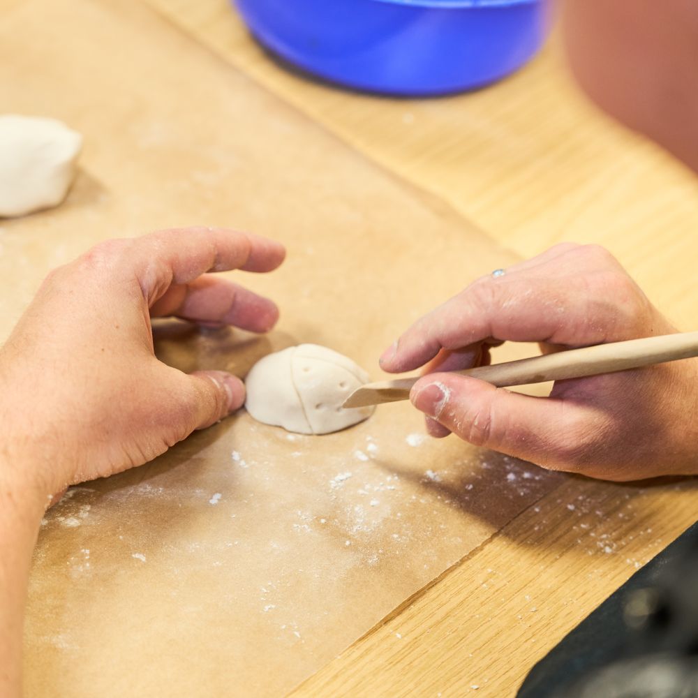 Hand formt Ton bei einer ergotherapeutischen Übung.